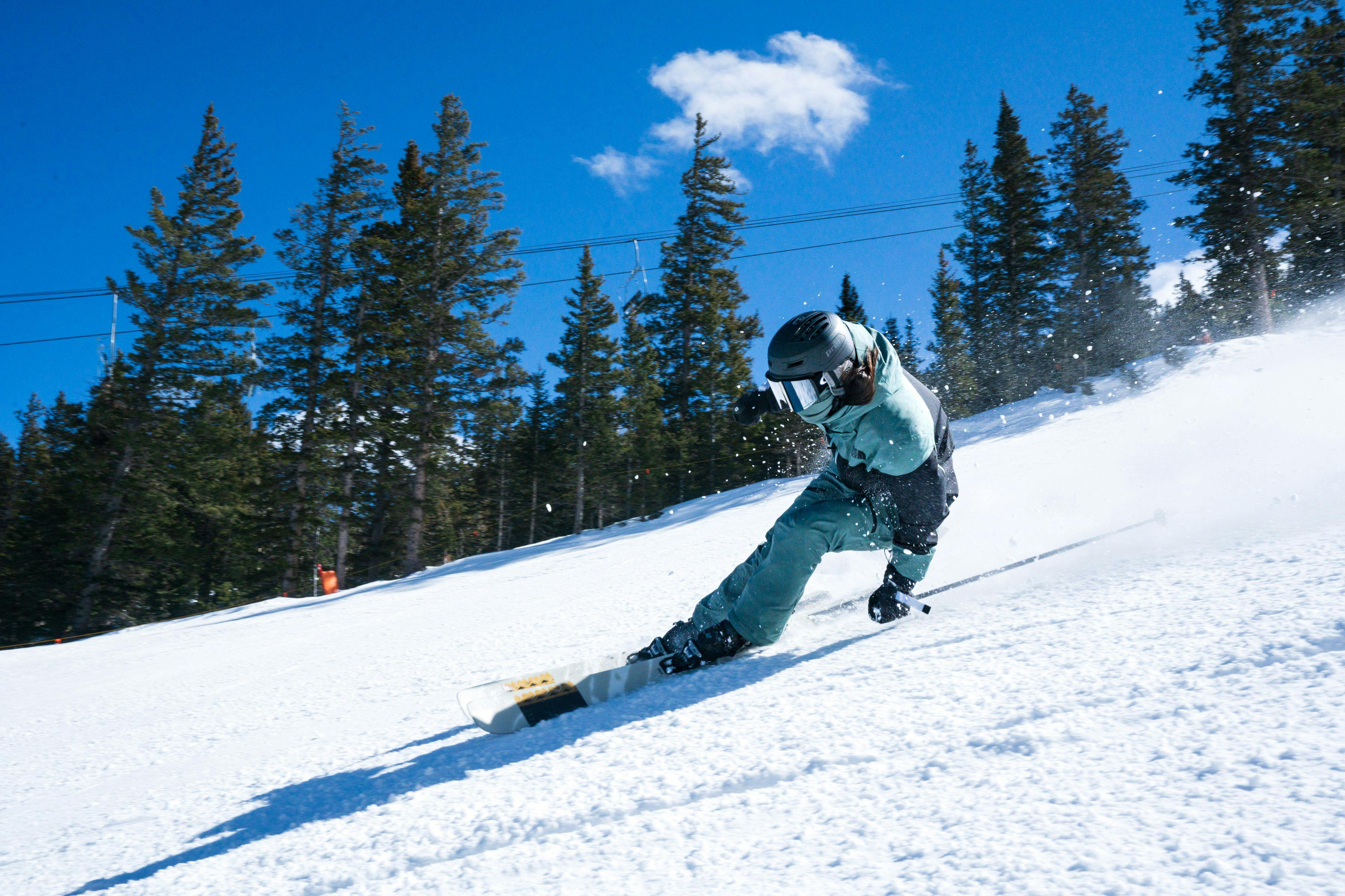 skier taking a tight low turn on a fast groomer at Taos Ski Valley